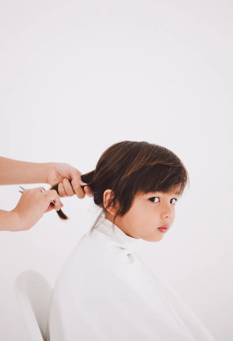 Profesional cortando el pelo a un niño con atención personalizada